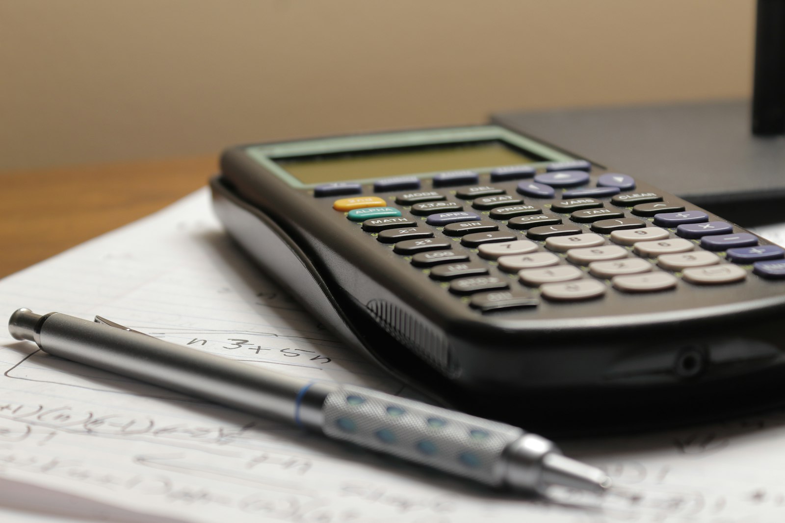 Notebook, calculator and laptop on a desk while working out how to price coaching sessions in South Africa