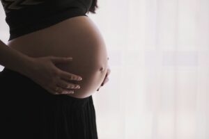 A doula holding a pregnant woman's hands during labour, illustrating what is a doula and how she supports birth
